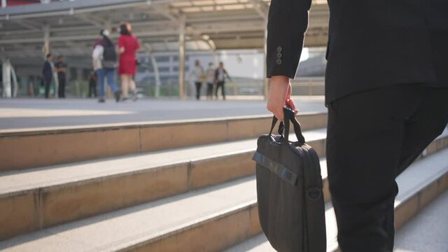 Close-up shot of Asian businessman walking up on stair, going to work.