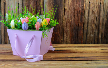 A beautiful bouquet of flowers made of natural soap in a pink paper gift box on a wooden background.space for text.