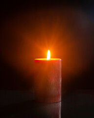 Red candle burning in the darkness.