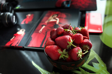 Macro photo of strawberries in a plate on the desktop.