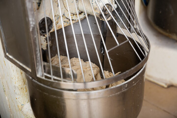 Making bread dough in kneading machine. Professional bakery equipment