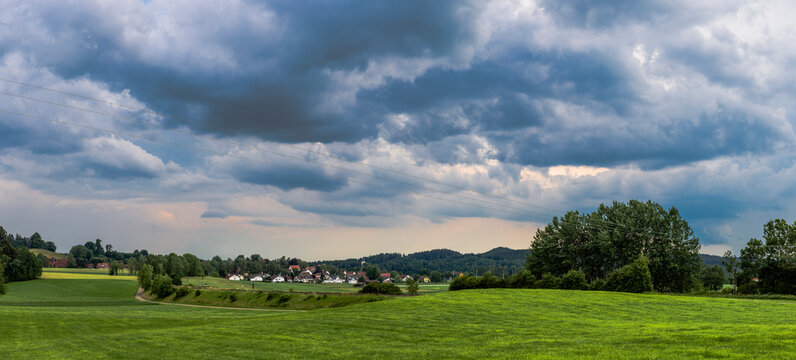 gloomy thunderclouds over a rural area with meadows and forest in the Baden Allg&auml;u near Wolfegg