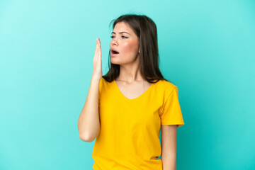 Young caucasian woman isolated on blue background yawning and covering wide open mouth with hand