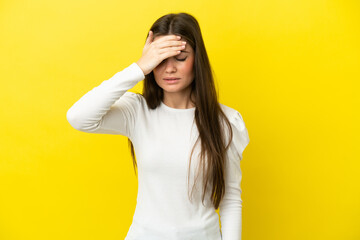 Young caucasian woman isolated on yellow background with headache