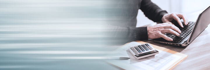 Accountant working on laptop; panoramic banner