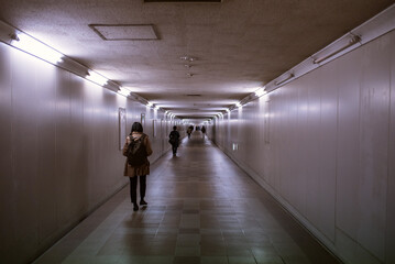 People walking in dark underground passage　暗い地下道を歩く人々