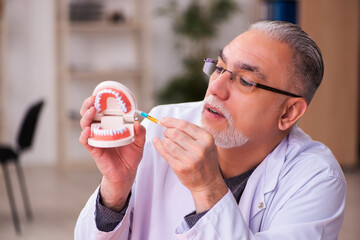 Old male dentist teacher sitting in the classroom