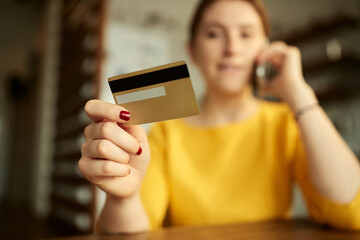 Close-up of woman using credit card while home shopping.
