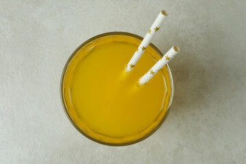Glass of orange soda on white textured background
