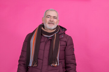 attractive senior man wearing anorak and scarf with background