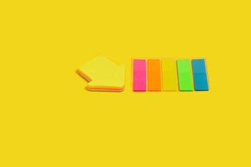 two different sticky note blocks on a yellow surface
