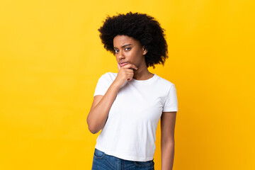 Young African American woman isolated on yellow background thinking