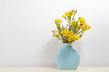 Little yellow flowers in blue vase, Still life background. - Powered by Adobe