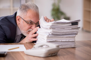 Aged male employee unhappy with excessive work in the office
