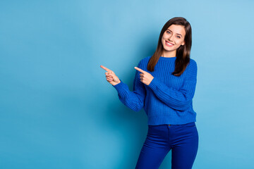 Photo of young beautiful smiling positive girl wear jeans and knitted jumper point finger copyspace...