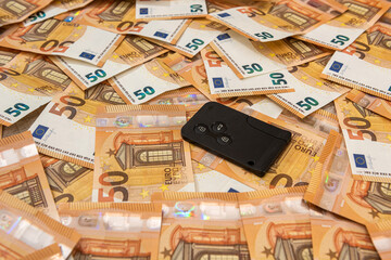  key for car and calculator on background of Euro bills