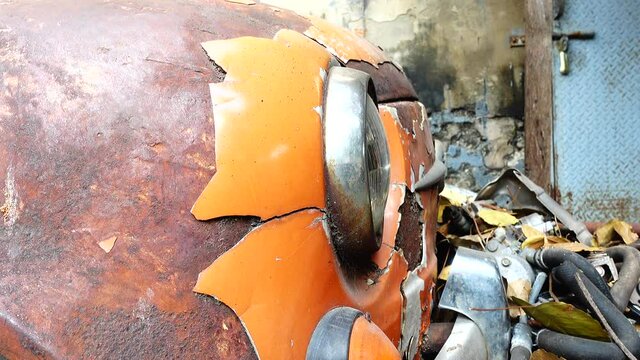 4K Old abandoned rusty white orange vintage car wreck in an old street
