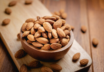 Almonds seed in the wooden bowl on the wooden table.