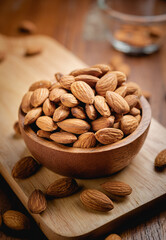 Almonds seed in the wooden bowl on the wooden table.