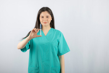 Portrait of female doctor holding a large syringe.