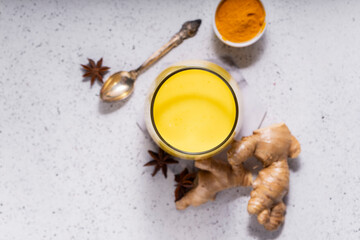 selective focus. Healthy ayurvedic drink golden almond milk or pumpkin turmeric latte with curcuma powder on white background. copy space.Trendy Asian natural detox beverage with spices for vegans