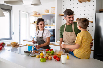 Happy family preparing healthy food together in kitchen