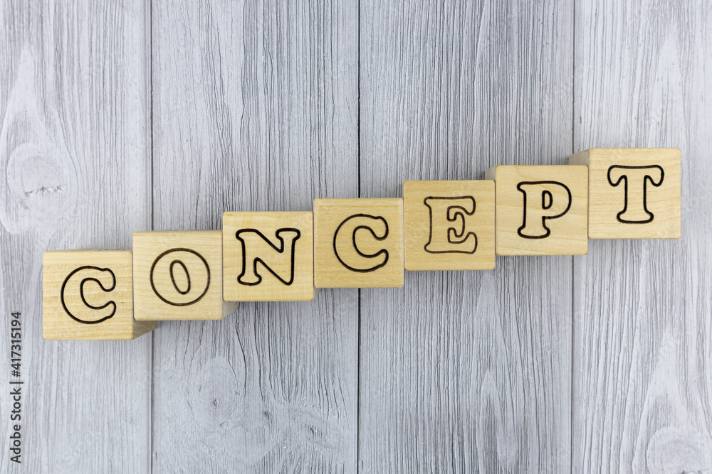 Fototapete wooden blocks with letters spelling the word - concept - arranged diagonally on a grey wood backgrou