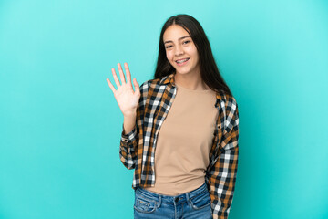 Fototapeta na wymiar Young French woman isolated on blue background saluting with hand with happy expression