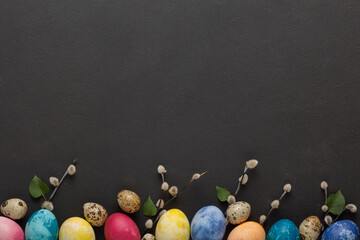 Easter eggs and pussy willow branches on a dark background. top view