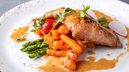 Stewed rabbit leg with vegetables. Closeup