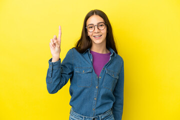 Young French woman isolated on yellow background pointing up a great idea