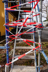 Fototapeta na wymiar Stockholm, Sweden No entry tape wrapped arounf scaffolding to prevent climbers.