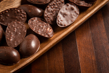 Mini halves of crunchy easter eggs on a wooden basket on a wooden table.