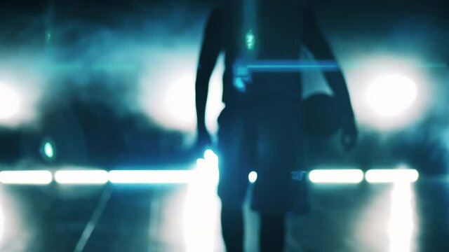 Blurred image of a basketball player walking along a dark room