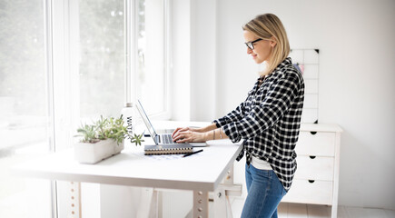 Fototapeta na wymiar Businesswoman working at a standing desk in a modern office space