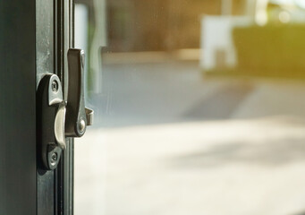 security lock on glass window with green garden outside view of home on sunlight background.