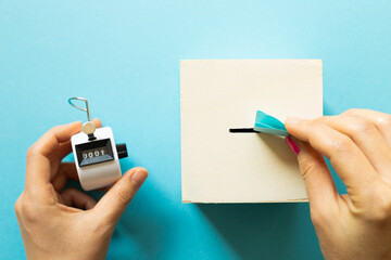 Voting box and tally counter on blue background. top view, copy space