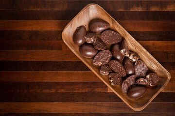 Top view of mini halves of crunchy easter eggs on a wooden basket on a wooden table.