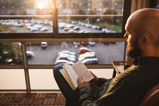 Man reading book on balcony