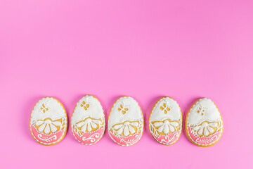 Beautiful Easter background or greeting card with colored pink gingerbread eggs on pink surface background. Happy Easter