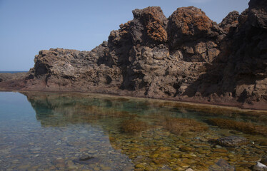 Fototapeta na wymiar Gran Canaria, calm natural seawater pools in under the steep cliffs of the north coast and separated from the ocean by volcanic rocks, Sardina del Norte area 