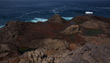 Gran Canaria, calm rock pools under steep cliffs of the north coast are 
separated from the ocean by volcanic rocks of platform constructed by old lava flows
Punta de Galdar area