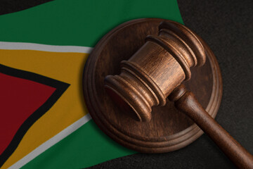 Judge gavel and flag of Guyana. Law and justice in Guyana. Violation of rights and freedoms