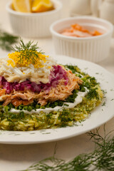 Traditional Russian Mimosa salad with salmon cheese and potatoes. Front view