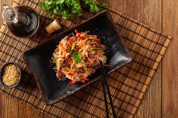 Oriental salad with rice noodles, chicken and mint. Top view.