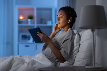 technology, internet and people concept - young african american woman with tablet pc computer and...
