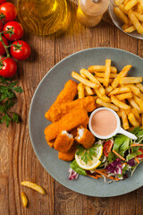 Fish sticks with fries and salad.