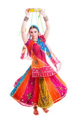 Beautiful female Bollywood dancer in traditional multicolored dress with veil and tambourine