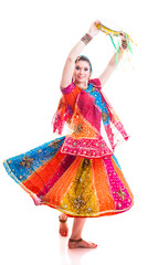 Beautiful female Bollywood dancer in traditional multicolored dress with veil and tambourine