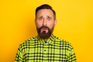 Portrait of attractive miserable unlucky devastated man wearing checked shirt isolated over bright yellow color background